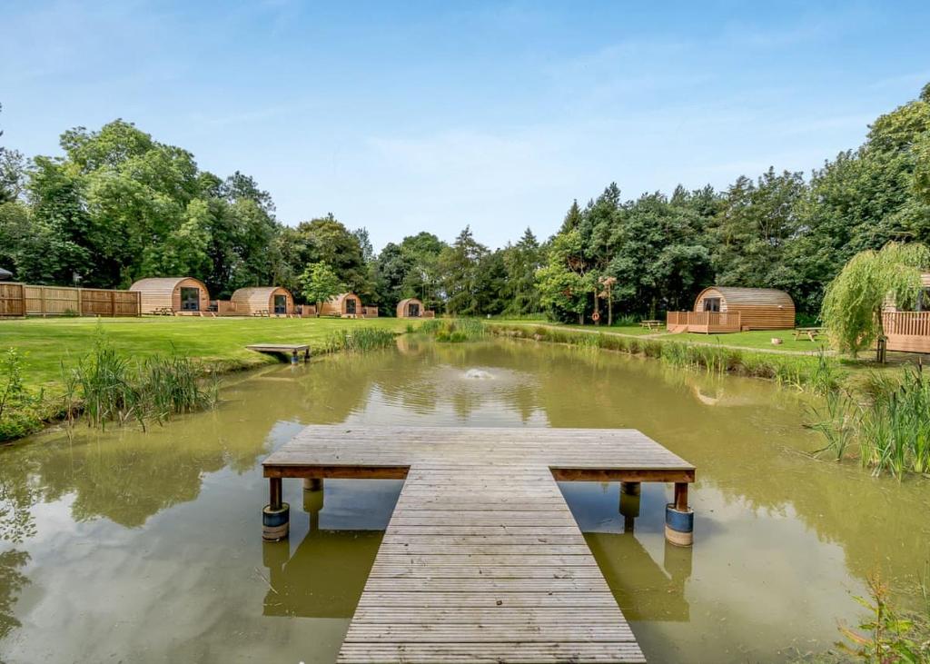 a wooden dock in the middle of a pond at Killerby Old Hall in Scarborough