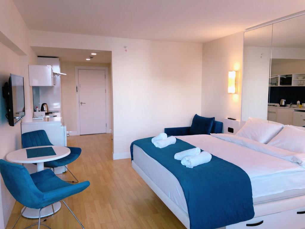 a bedroom with a large bed and a table and chairs at Beachfront Apartaments in Orbi City in Batumi