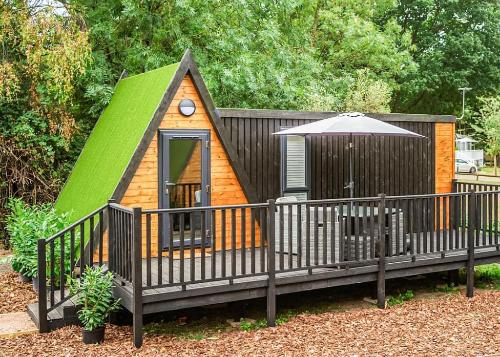 Una pequeña casa de juegos con techo verde en Lee Valley Sewardstone, en Enfield Lock