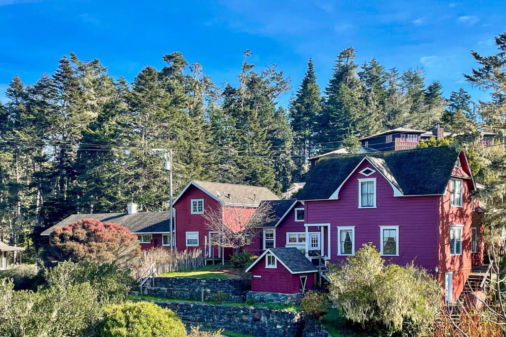 ein rotes Haus im Wald mit Bäumen in der Unterkunft Big River Retreat in Mendocino