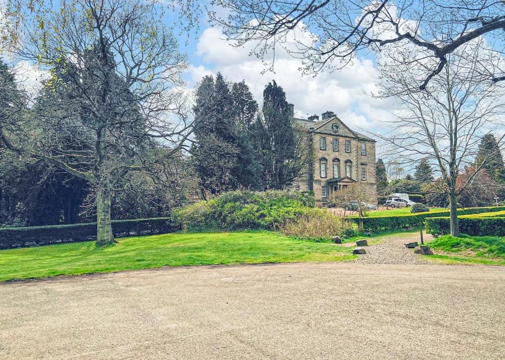 una grande casa con un cortile verde davanti di Mortonhall Park a Edimburgo