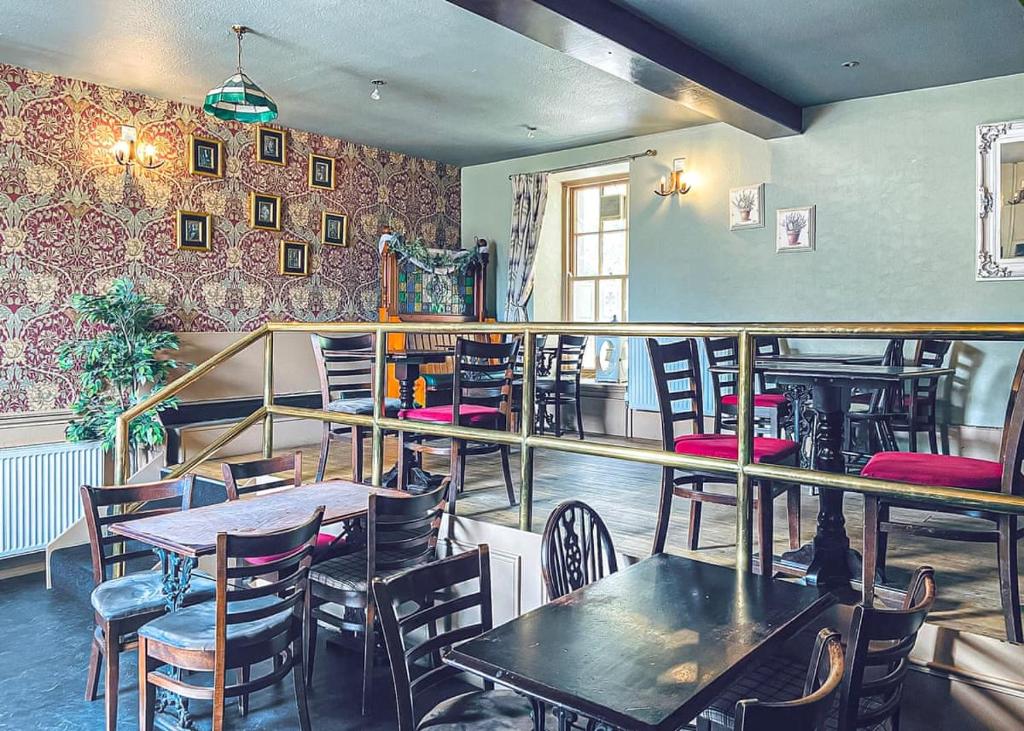 un ristorante con tavoli e sedie in una stanza di Mortonhall Park a Edimburgo