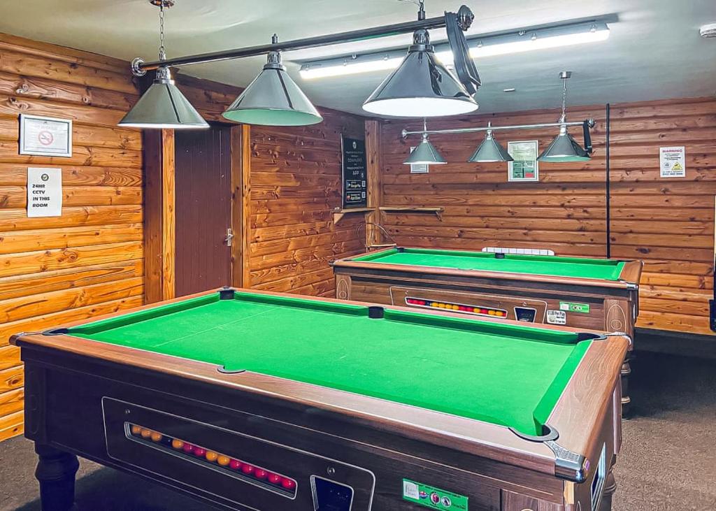 una sala biliardo con due tavoli da biliardo e luci di Mortonhall Park a Edimburgo