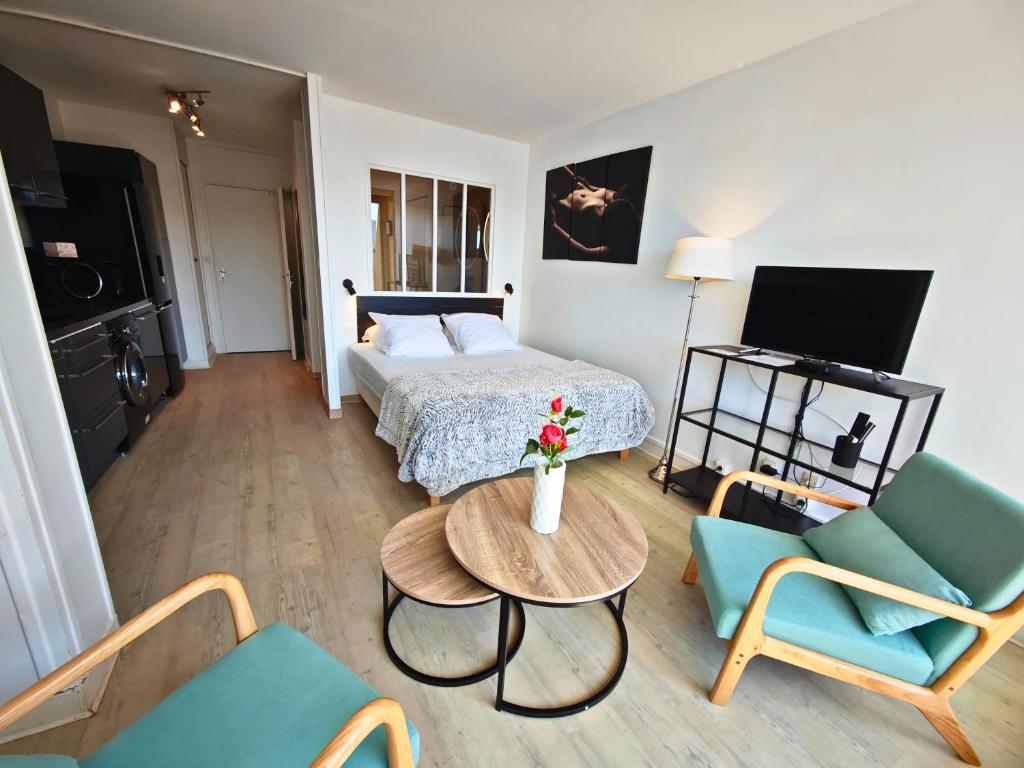 une chambre d'hôtel avec un lit, une table et des chaises dans l'établissement Studio Desobeissance Village Naturiste, au Cap d'Agde