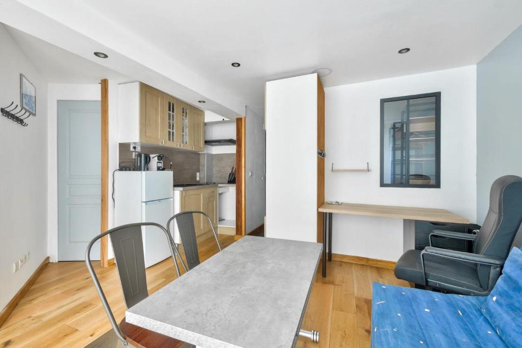 une cuisine et une salle à manger avec une table et des chaises dans l'établissement Ideal location for this pleasant studio, à La Rochelle