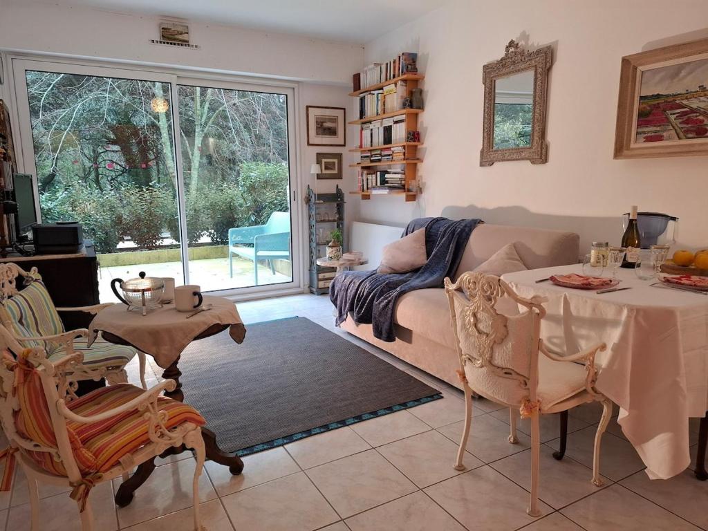 un salon avec une table et un canapé dans l'établissement Entre plage et forêt, à La Baule