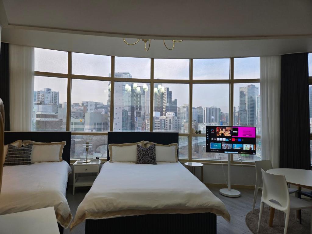 a hotel room with two beds and a large window at Gleam House in Seoul