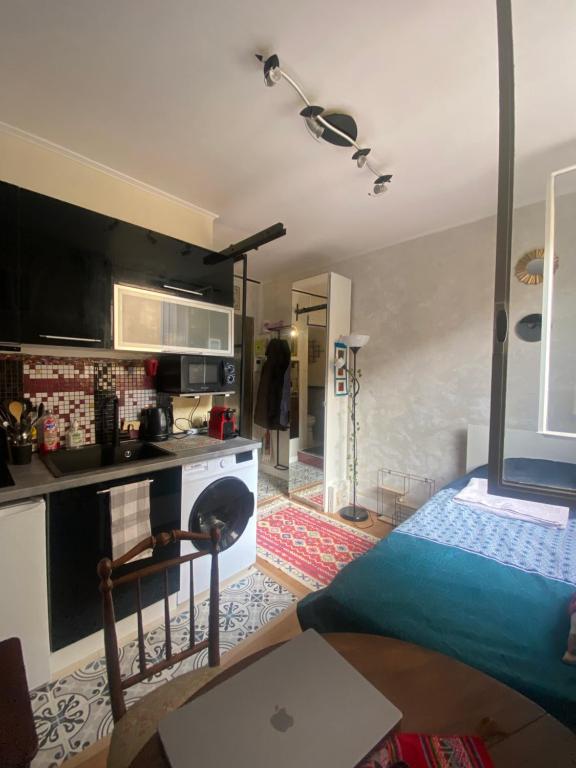 un salon avec un lit et une cuisine dans l'établissement Charming Arty Studio, à Paris