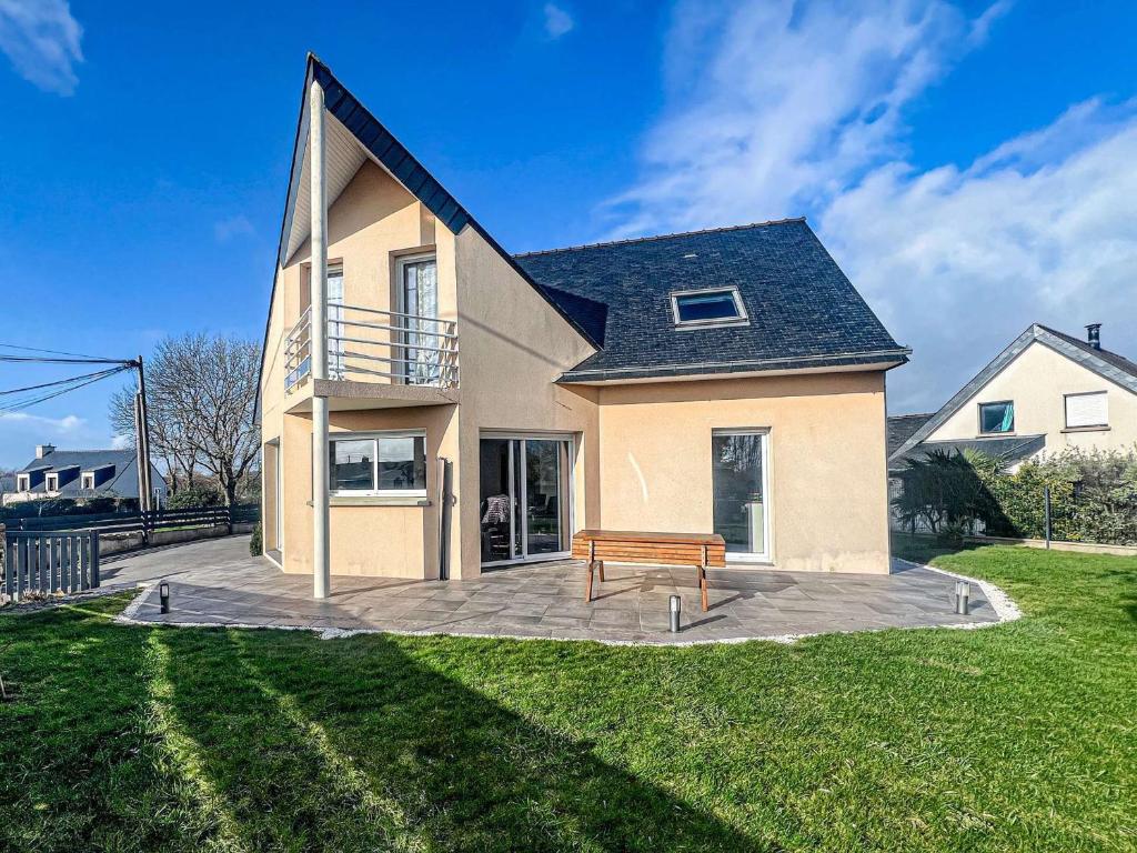 une maison avec un banc devant dans l'établissement Maison contemporaine à Erdeven - 5 chambres, animaux acceptés - FR-1-479-223, à Erdeven