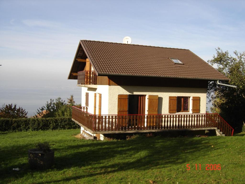 a small house with a deck on a green field at Vue exceptionnelle sur le lac in Lugrin