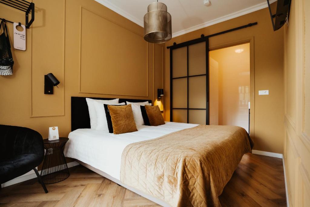 een slaapkamer met een groot wit bed en een stoel bij Hotel Janssen in Valkenburg