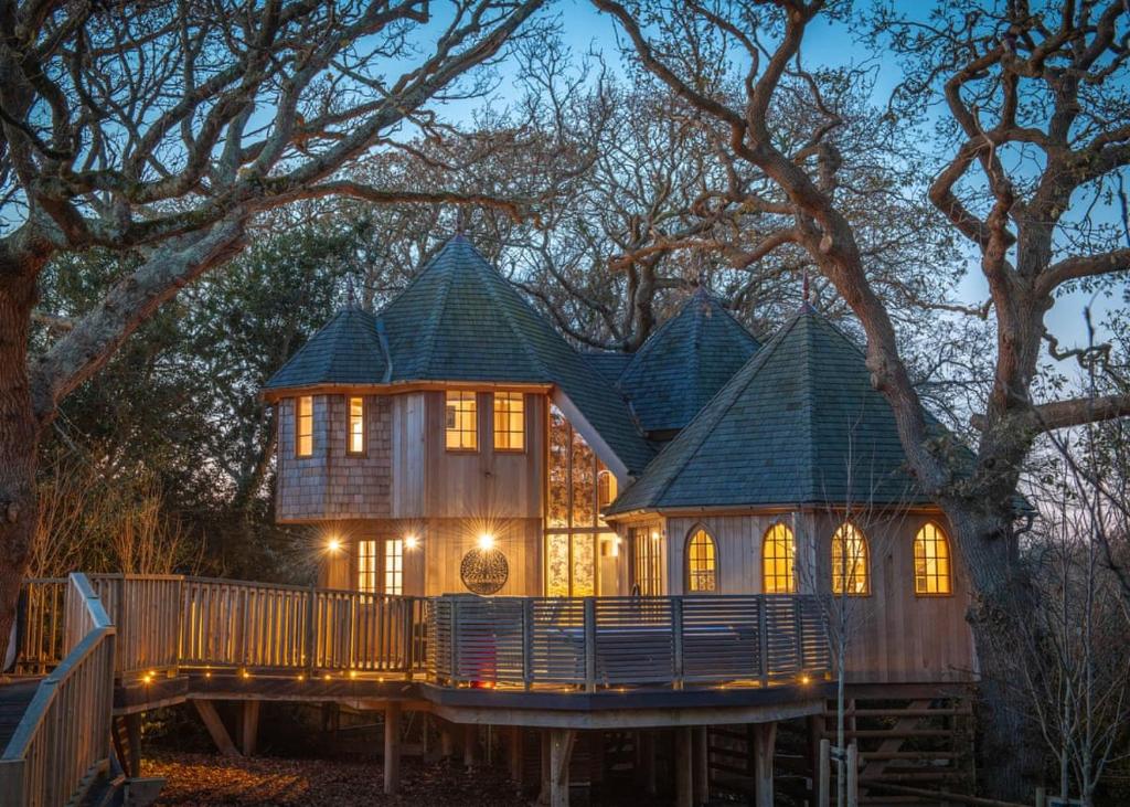 una casa en un árbol en una cubierta por la noche en Shorefield Country Park, en Milford on Sea