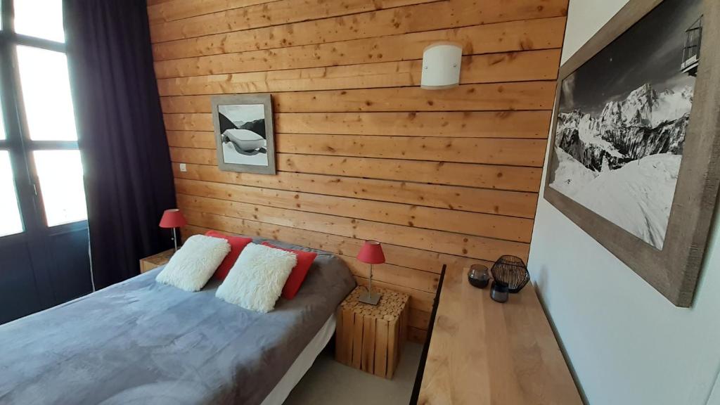 a bedroom with wooden walls and a bed with pillows at Nid cosy avec vue montagne au coeur de saint lary in Saint-Lary-Soulan