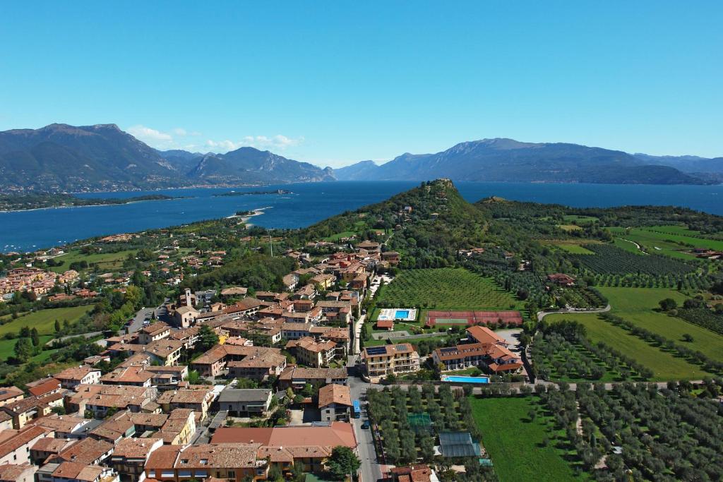 z powietrza widok na małe miasteczko obok jeziora w obiekcie Spa Hotel Splendid Sole w Manerba del Garda