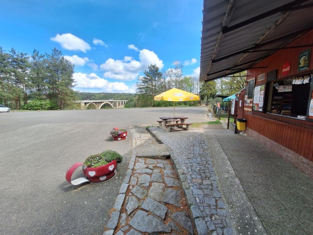 un tavolo da picnic con un ombrellone accanto a una strada di Chatka u Podolského mostu - Temešvár - 5 lůžek a Temešvár