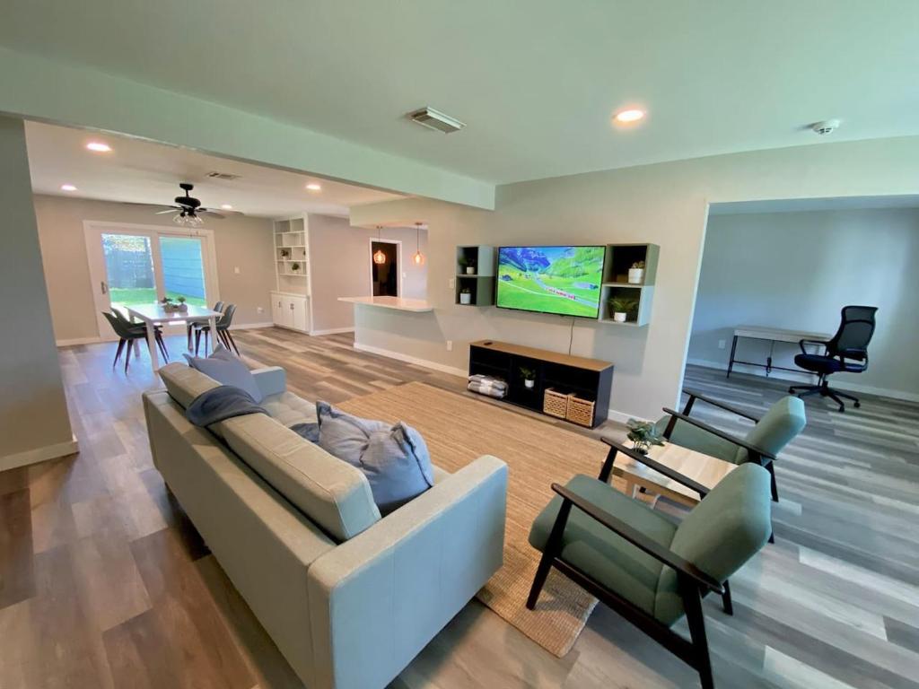 Una gran sala de estar con un sofá y un televisor. en 3-BR Getaway Ideal for Families, en Houston