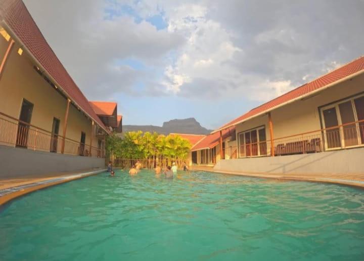 a group of people in the water in a swimming pool at Break the Routine, Malshej in Murbād