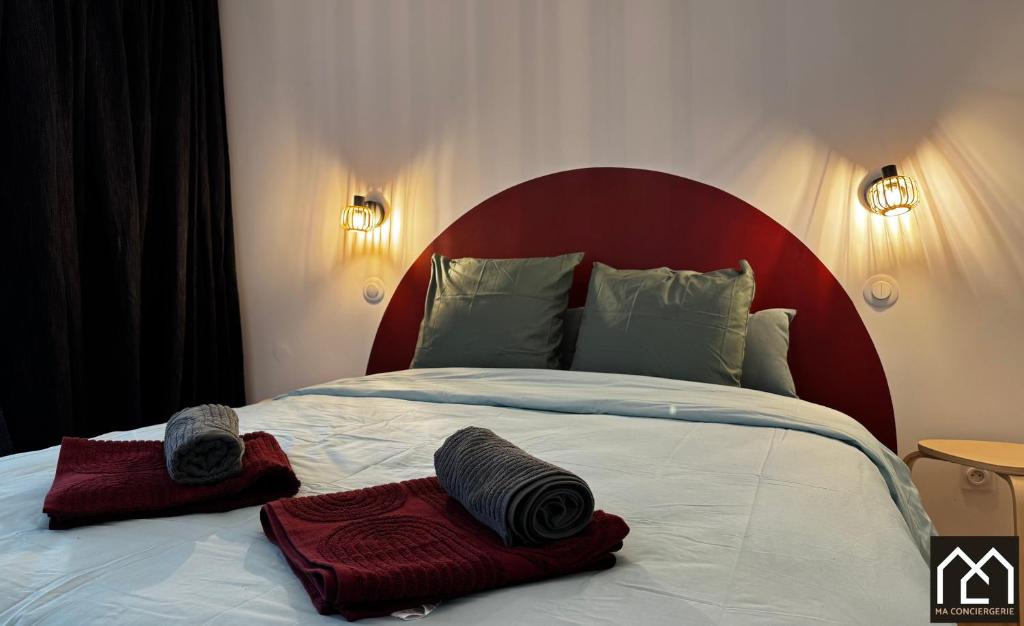 un lit avec deux oreillers dessus dans l'établissement La Maison de Clocheville - Appartements tout confort, à Boulogne-sur-Mer