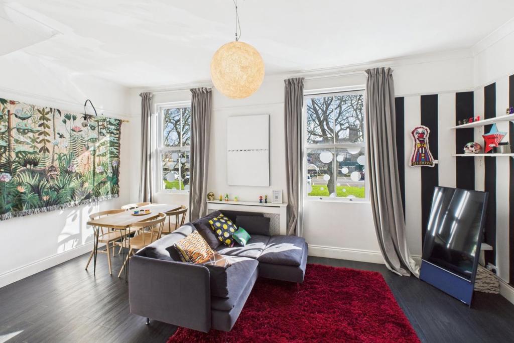 een woonkamer met een bank, een tv en een tafel bij Host & Stay - The Artists Pad in Saltburn-by-the-Sea