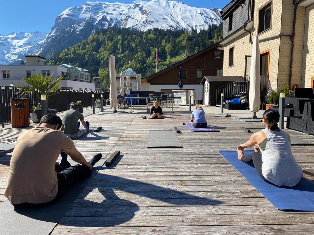 a group of people sitting in the street doing yoga at Hotel Central in Engelberg