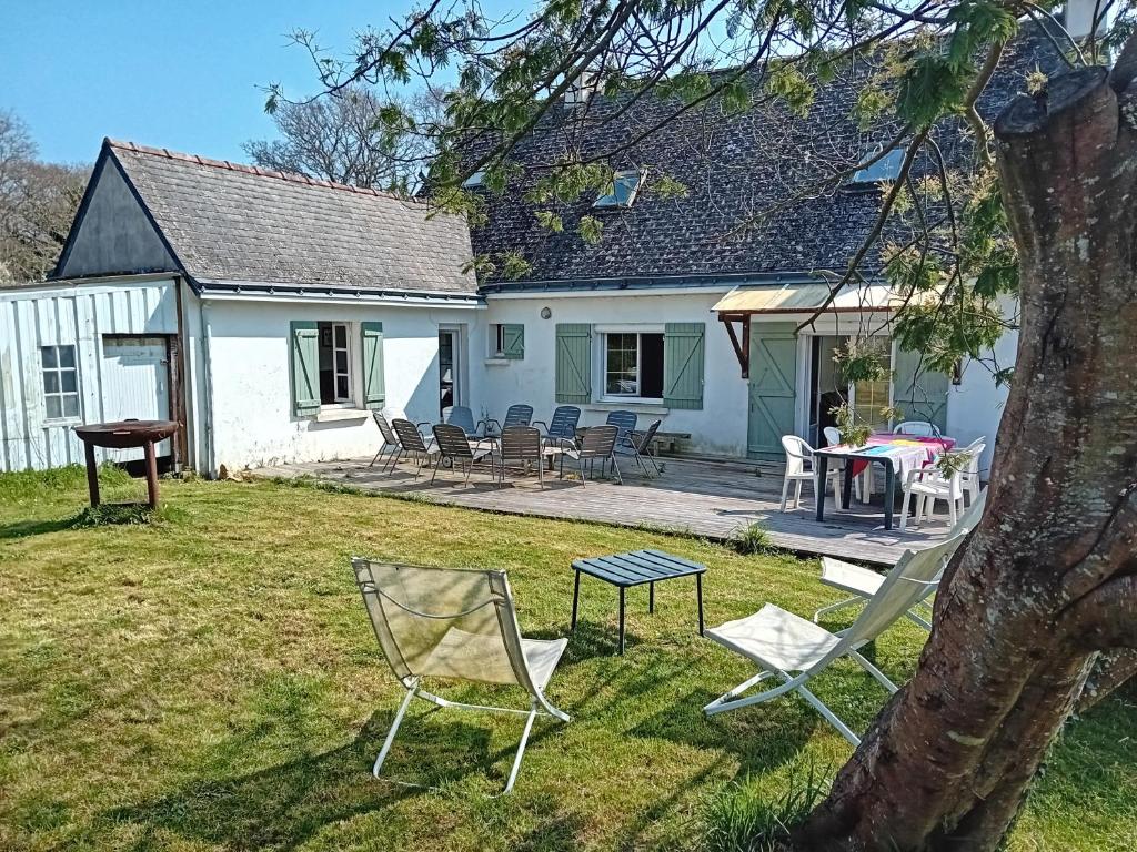 une maison avec des chaises et une table dans la cour dans l'établissement Cap Mer - Maison 500m plage du Palandrin, à Pénestin