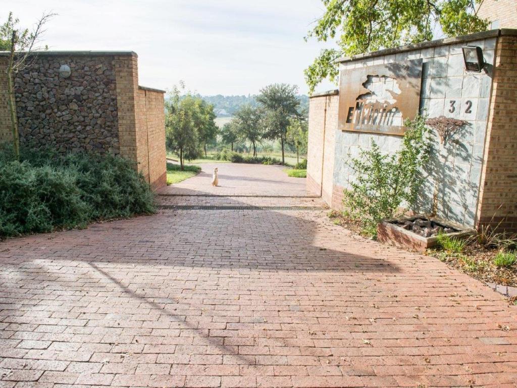 an empty brick road with a sign on the side of a building at Emzini Apartments in Midrand