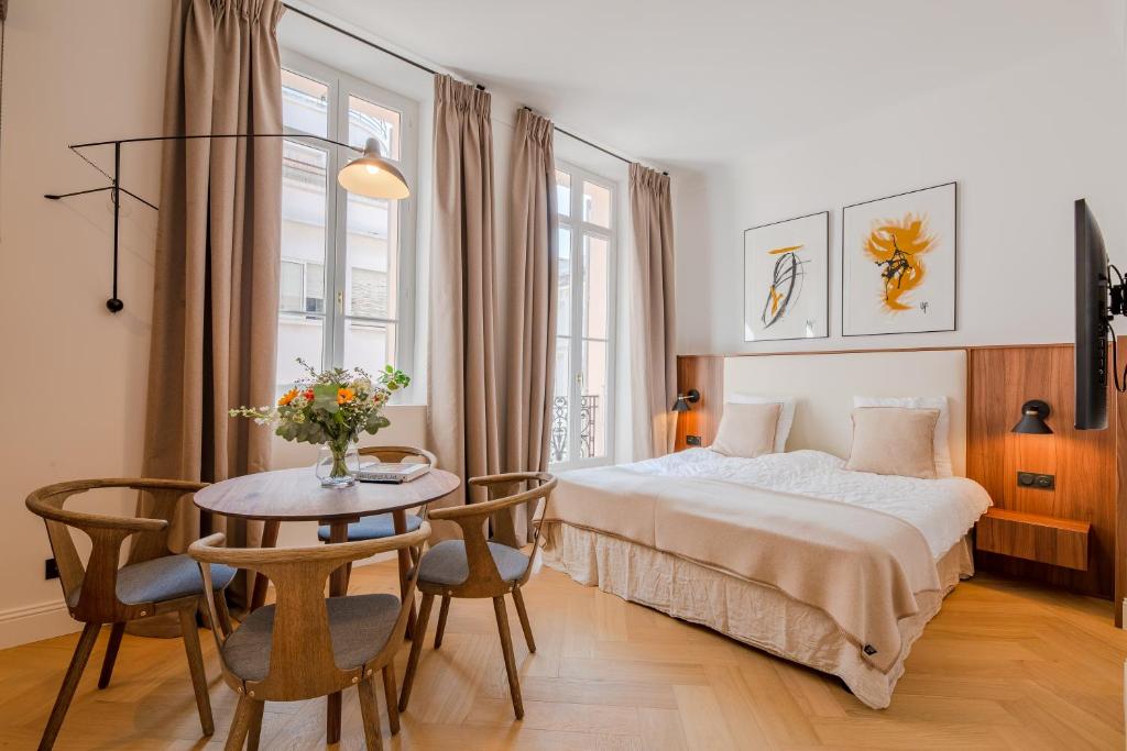 une chambre d'hôtel avec un lit et une table dans l'établissement La Guitare 21 - Cozy studio in center of Cannes, just behind Grand Hotel, à Cannes