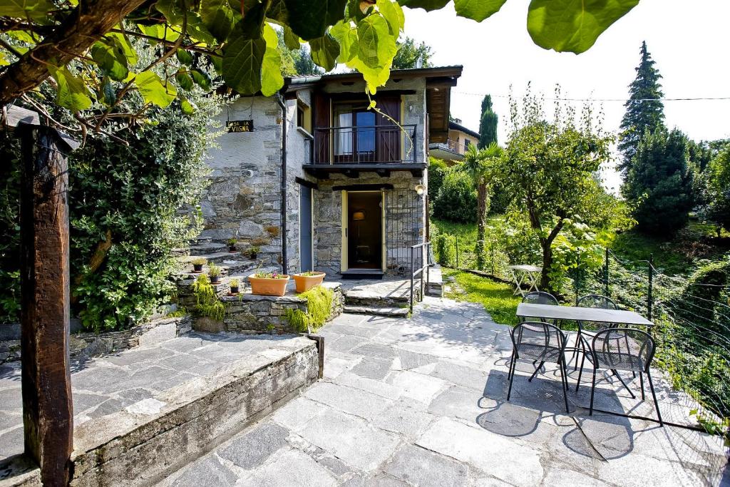 a patio with a table and chairs in front of a house at Rustico La Vigna in Cannero Riviera