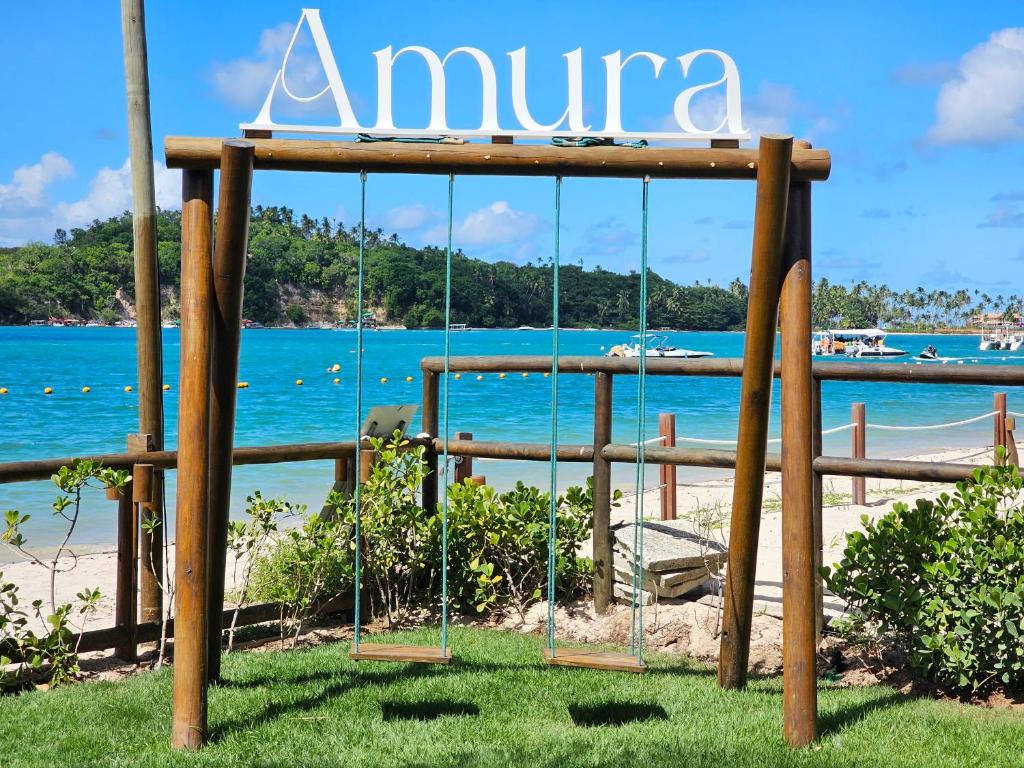Signe qui dit amuna avec une planche de surf dans l'établissement Amura Carneiros - Pé na areia - Trecho Exclusivo, à Praia dos Carneiros