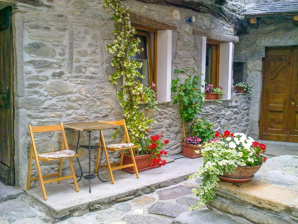 dos sillas y una mesa frente a un edificio con flores en Casa delle Antiche Pietre, en Cannero Riviera
