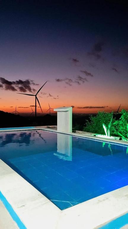 a swimming pool with a sunset in the background at Margarida 04 in Monte das Gameleiras