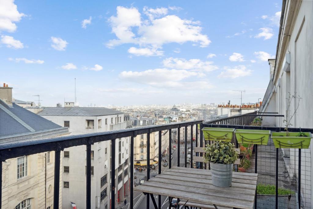 d'un balcon avec un banc en bois et une vue sur la ville. dans l'établissement Amazing view apartment in heart of Paris, à Paris