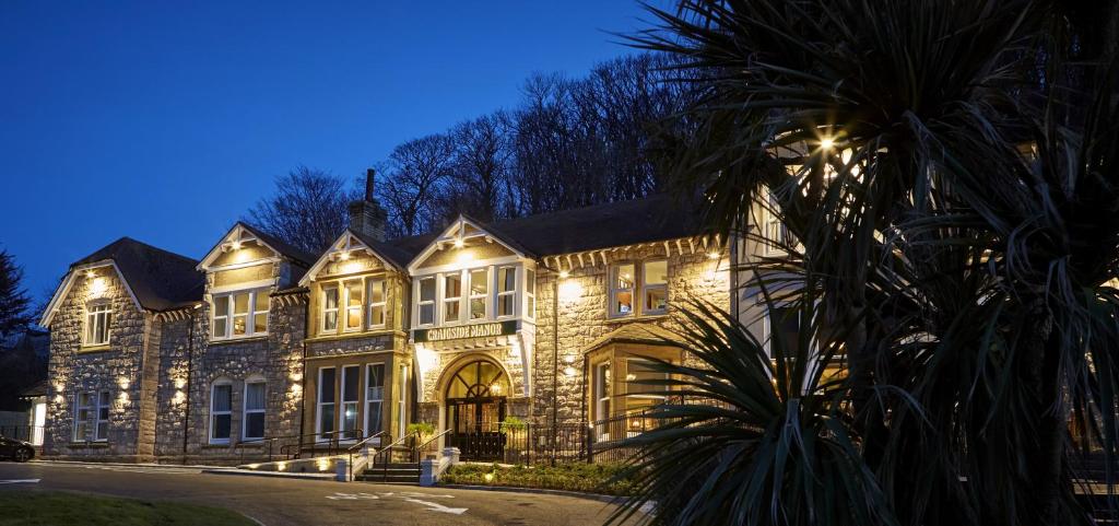 a large building with lights on it at night at Craigside Manor in Llandudno