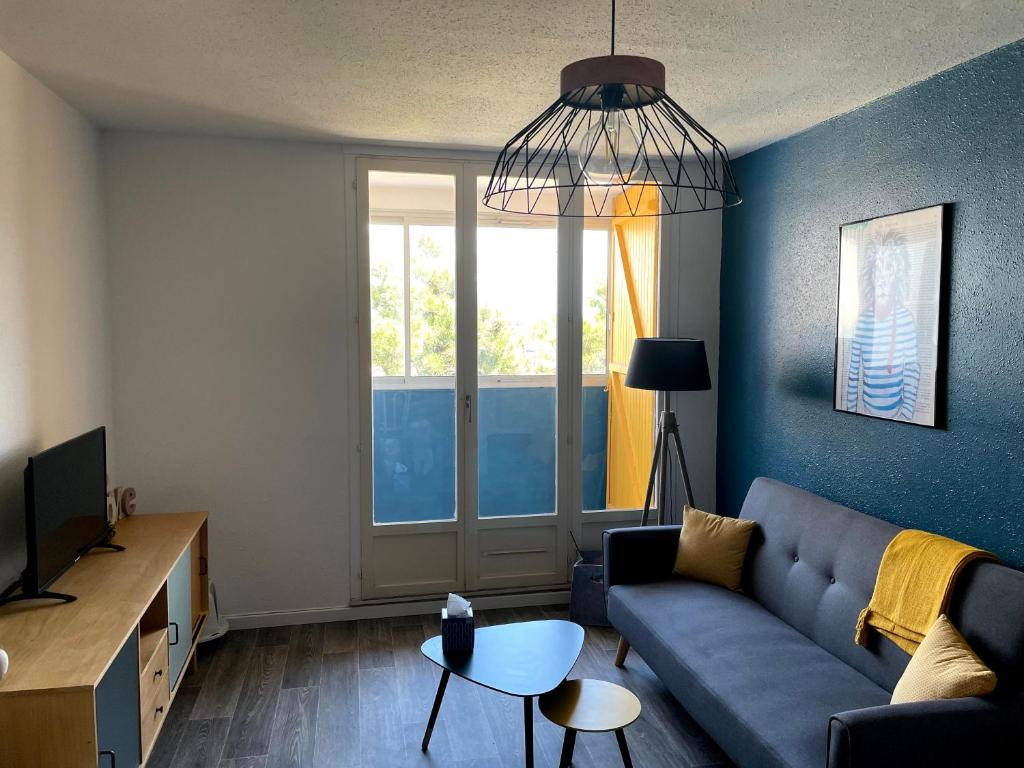 un salon avec un canapé et une grande fenêtre dans l'établissement Le Galion, à Saint-Hilaire-de-Riez