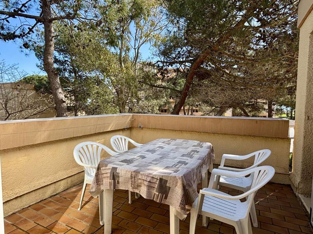 une table et des chaises assises sur une terrasse couverte avec une table et des chaises dans l'établissement Appartement 2 pièces avec garage privé et terrasse, à 80 m de la mer, classé 2 étoiles, Argelès-sur-Mer - FR-1-225-82, à Argelès-sur-Mer