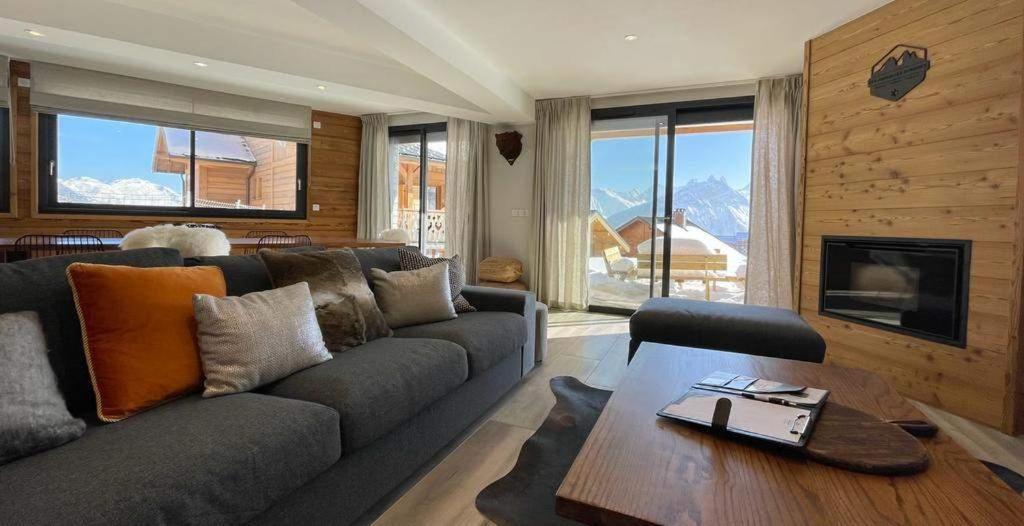 un salon avec un canapé et une table dans l'établissement SUNWEB Chalet Mont Thabor, à La Toussuire