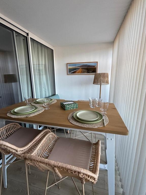 une table avec deux chaises et une table avec des assiettes et des verres dans l'établissement Studio cosy et rénové - vue port, à Capbreton