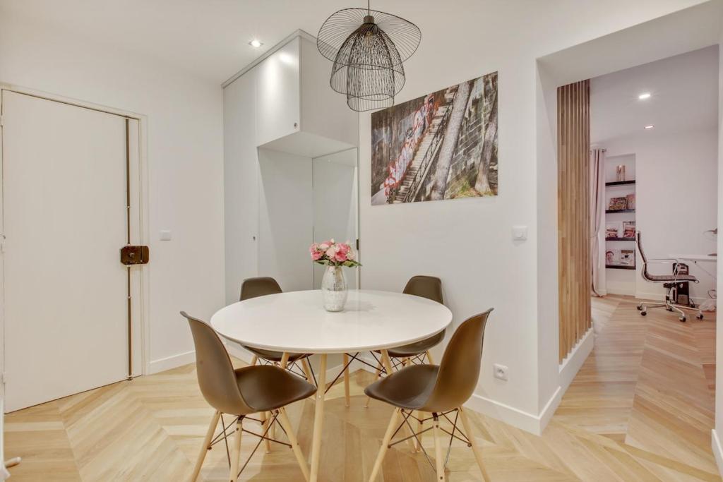 une salle à manger blanche avec une table et des chaises blanches dans l'établissement 4-Star Apartment for 4, 10 mn from Champs-Élysées, à Paris