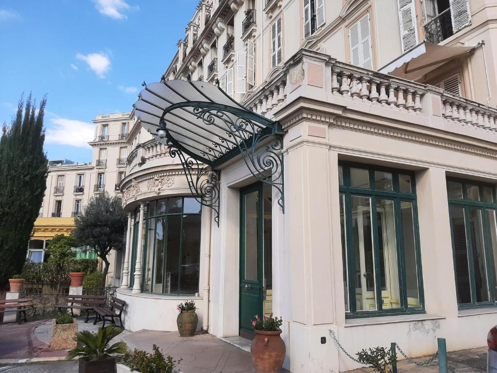- un grand bâtiment blanc avec une porte en verre dans l'établissement Le Petit Palais, à Menton