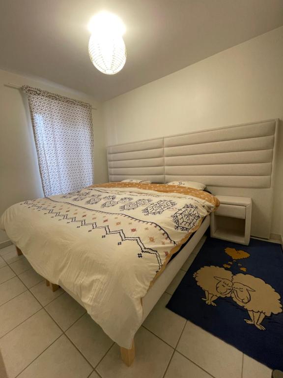 une chambre avec un lit avec une couette dessus dans l'établissement Maison Confortable, à Saint-Martin-Belle-Roche