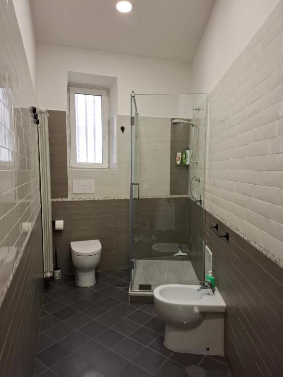 a bathroom with a toilet and a shower and a sink at Alicja House in Casoria