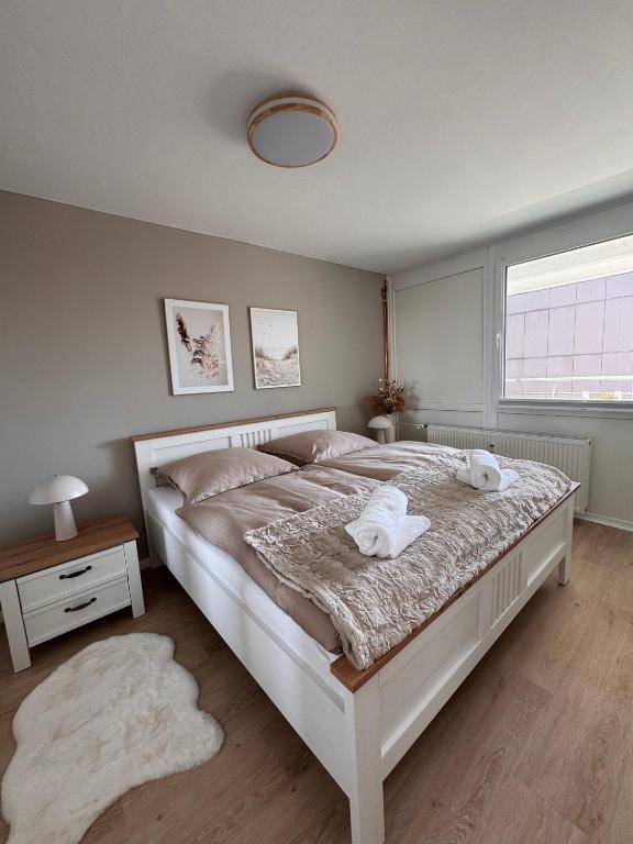 a bedroom with a large bed with two towels on it at Fewo Strandbrise in Eckernförde