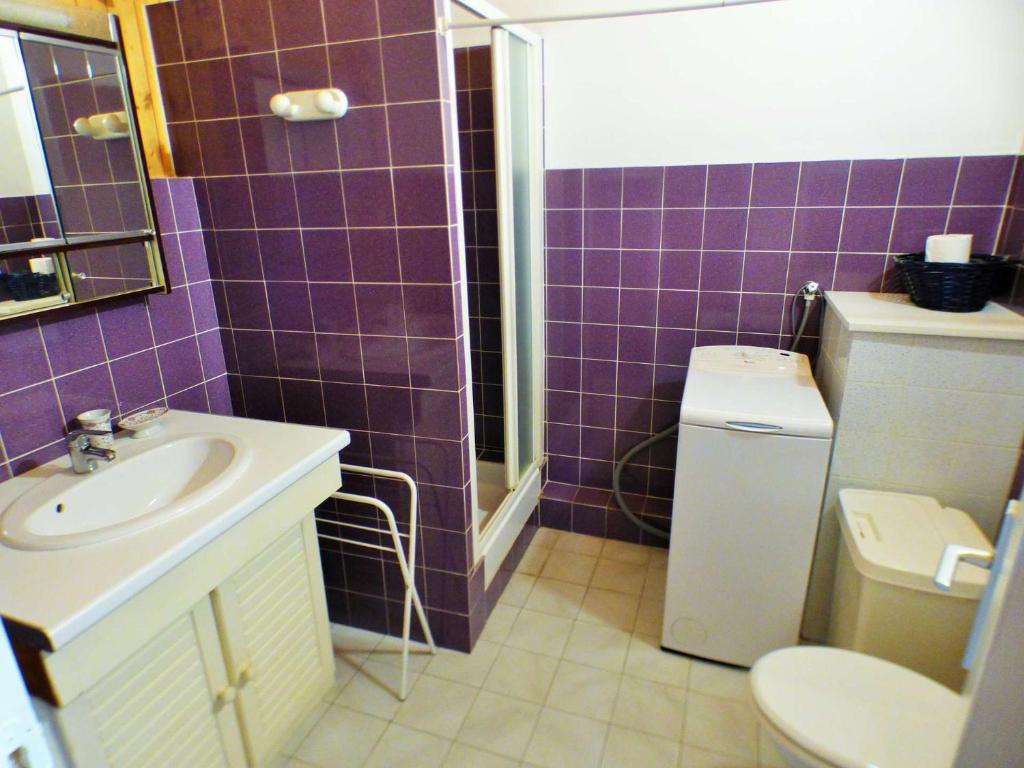 La salle de bains est pourvue de carrelage violet, d'un lavabo et de toilettes. dans l'établissement Duplex sur le port du Brusc, Plage, Embarcadère, Commerces à pieds, à Six-Fours-les-Plages