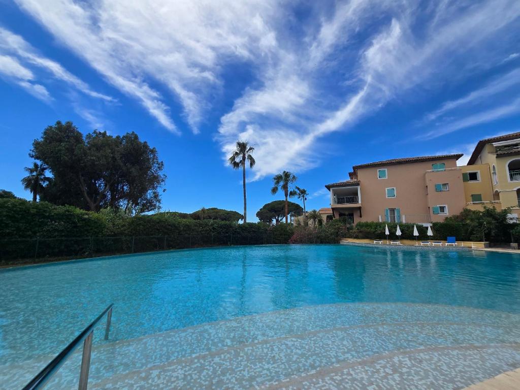 ein großer Pool mit einer Palme im Hintergrund in der Unterkunft Les rives des Issambres 1201 in La Garonnette-Plage