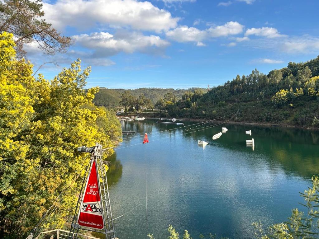 a sailboat on a river with boats in the water at Retiro do Lago in Ferreira do Zêzere