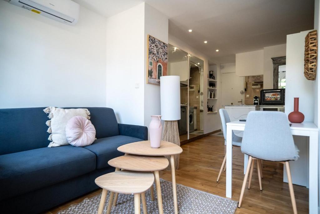 un salon avec un canapé bleu et une table dans l'établissement GuestReady - Enchanted stay with garden in Cimiez, à Nice