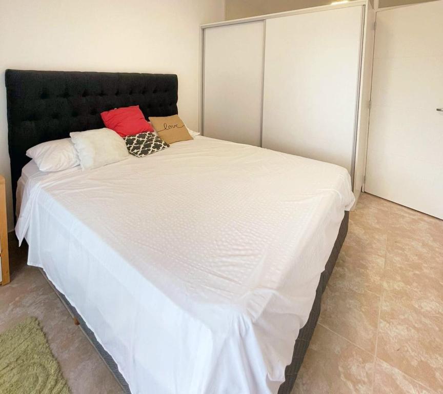 a large white bed with a black headboard in a room at Nisen Temporarios in La Plata