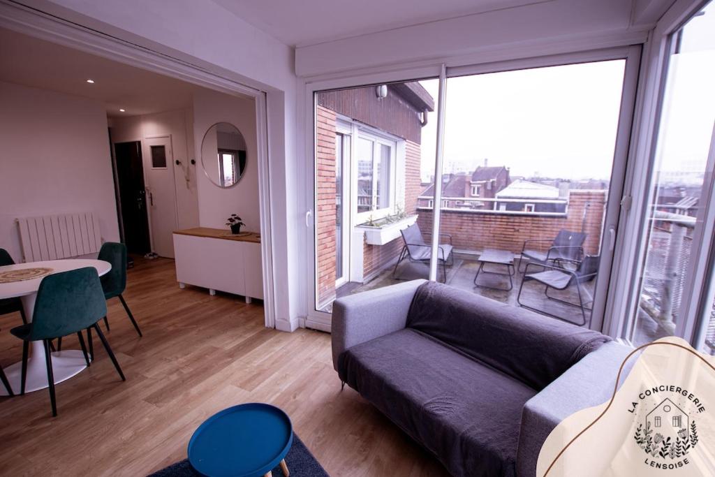 un salon avec un canapé et une grande fenêtre dans l'établissement Le Panoramic lensois, à Lens