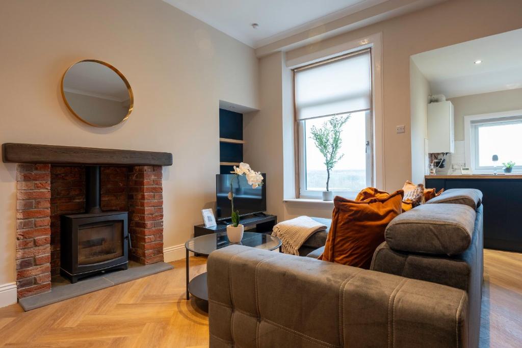 a living room with a couch and a fireplace at Station Road Stays in Kirk of Shotts