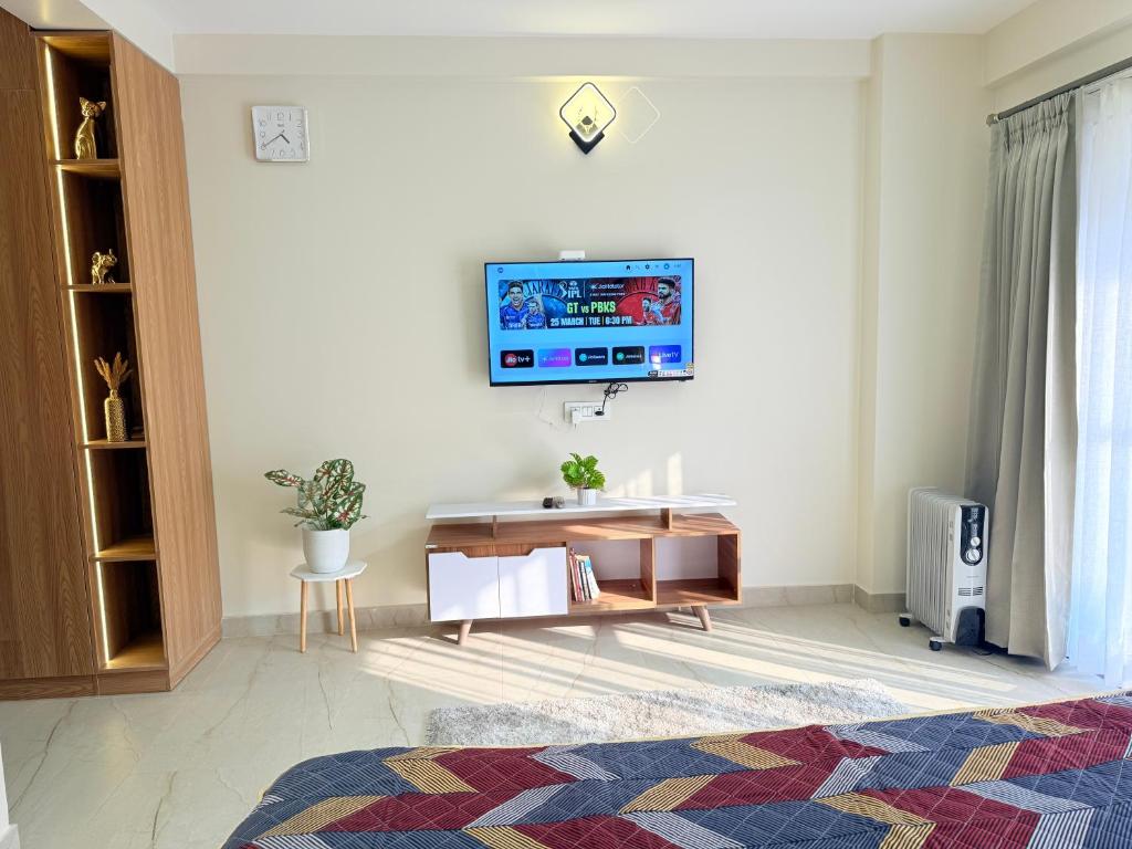 a living room with a tv on a wall at Cookies Home in Dehradun